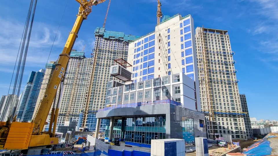 Modular building units being installed by crane at a construction site